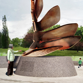 A close-up view of the bottom portion of a tall bronze sculpture sitting on a plinth. The spiraling sculpture is composed of sugar maple seeds swirling in the wind or rooting into the ground. One person is touching the sculpture. Others are sitting on stone benches and walking in the background, which is covered by lush green trees.