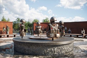 Four flak jackets and helmets are displayed on crosses and arranged in a circle. They sit on top of a raised round stone shape.