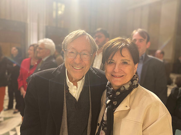 Deborah Lyons et Irwin Cotler souriant devant des personnes debout dans une pièce