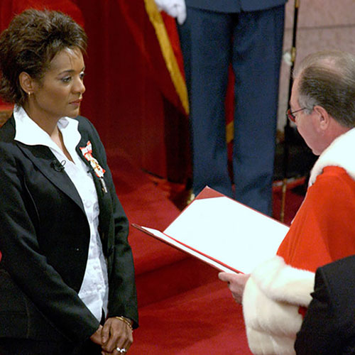 Michaëlle Jean standing and listening to a judge reading aloud.