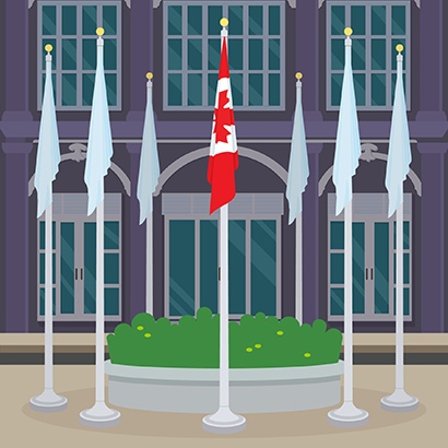 Drapeaux déployés sur des mâts fixes disposés en cercle autour d’un jardin circulaire surélevé aménagé devant l’entrée d’un immeuble de briques; le drapeau national du Canada est au centre et au premier plan. 