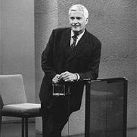 John Turner is standing and leaning against a podium.