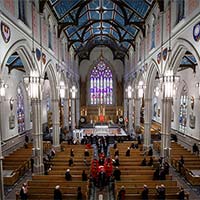 Plan intérieur de la cathédrale, incluant ses grandes arches. Au bas de la photo se trouve le cercueil drapé du drapeau national du Canada, et porté par des porteurs de la GRC.