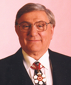 A head and shoulders colour photograph of smiling Governor General Romeo LeBlanc wearing his Companion of the Order of Canada medal.