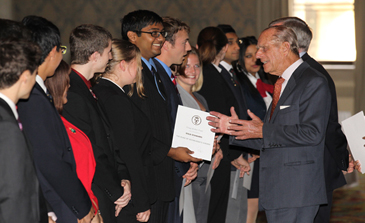 Prince Philip in conversation with a row of people in front of him.