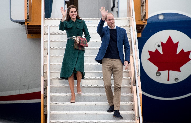 Leurs Altesses Royales tout sourire envoient la main en descendant d'un avion.