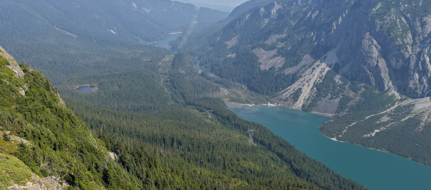 A body of water in a valley. Two transmission lines on land