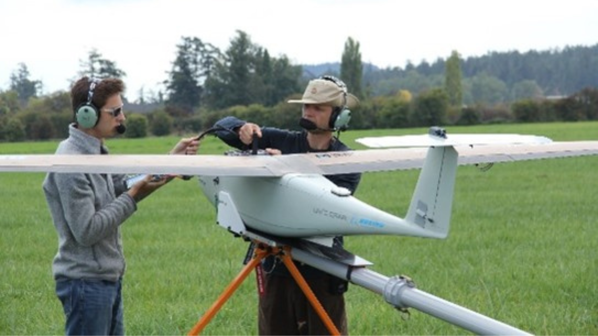 Image of two men working in a drone on a field