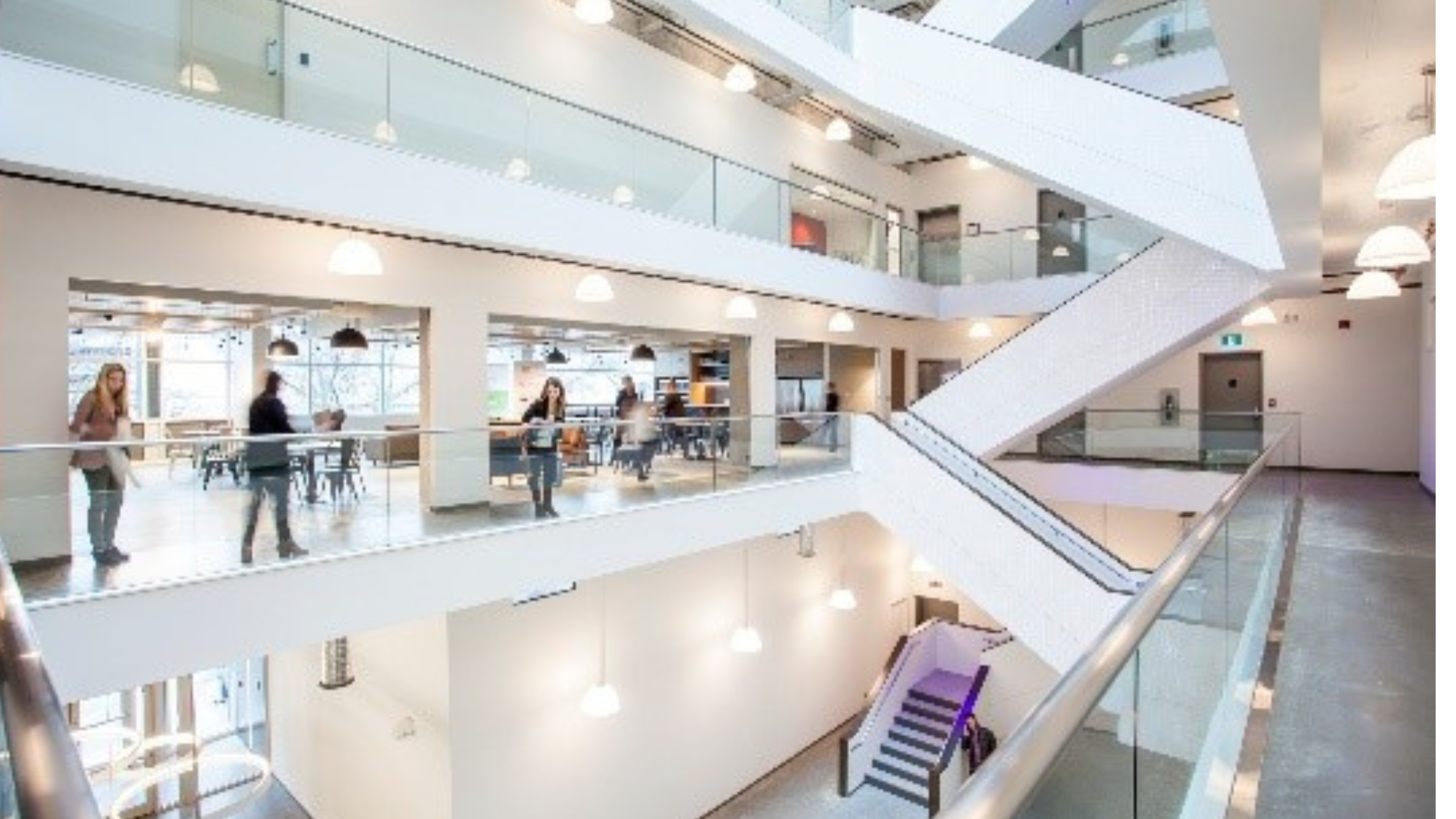 Kelowna Innovation Centre interior, with white staircases, people walking and brightly lit hallways