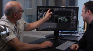 Deux hommes regardent une scanographie numérique d’un cœur sur un écran placé entre eux