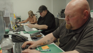 Staff of a local Fort McMurray business working on computers to help serve clients