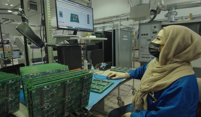 An employee inspects circuit boards in Levven Electronics' manufacturing facility