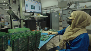 Un membre du personnel inspecte des circuits imprimés dans l'usine de fabrication de Levven Electronics.