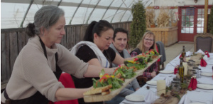 Les visiteurs se réunissent autour d'une table à manger à Prairie Gardens et se voient servir des plats composés d'aliments cultivés localement.