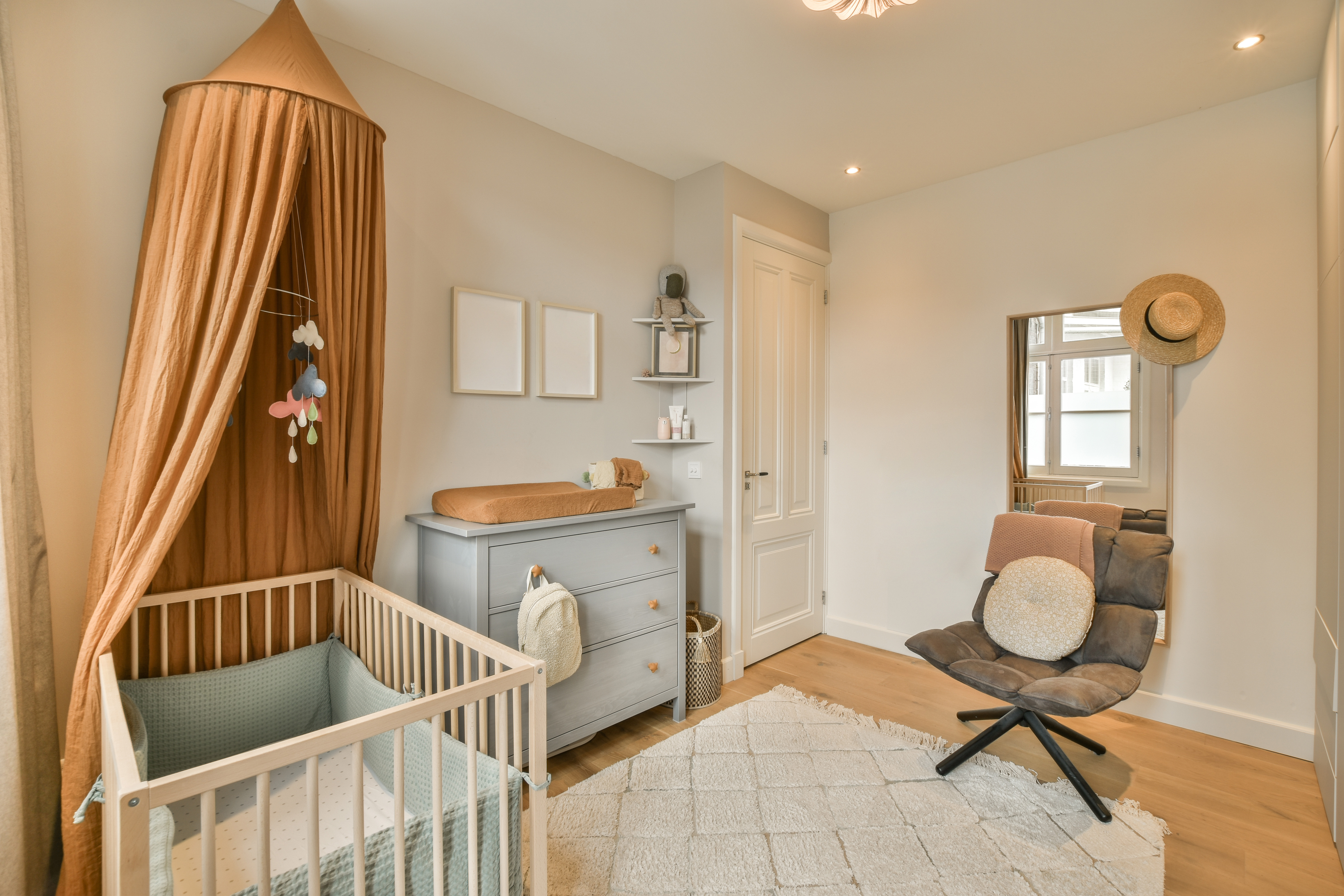 Une chambre d'enfant avec un lit d'enfant équipé de tours de lit et d'un baldaquin suspendu au-dessus du lit.