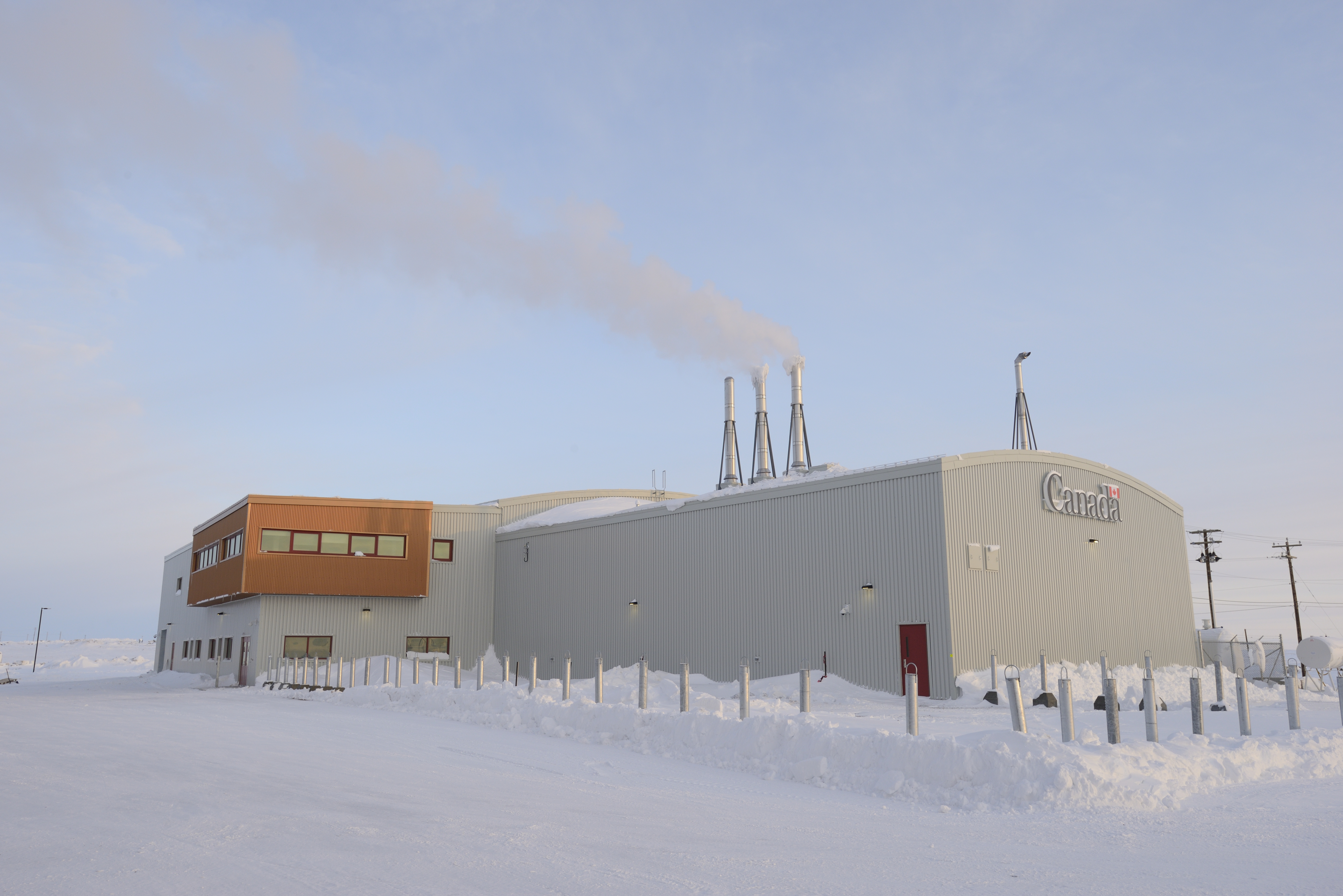 A large warehouse building in winter. The word Canada is on the front of it.