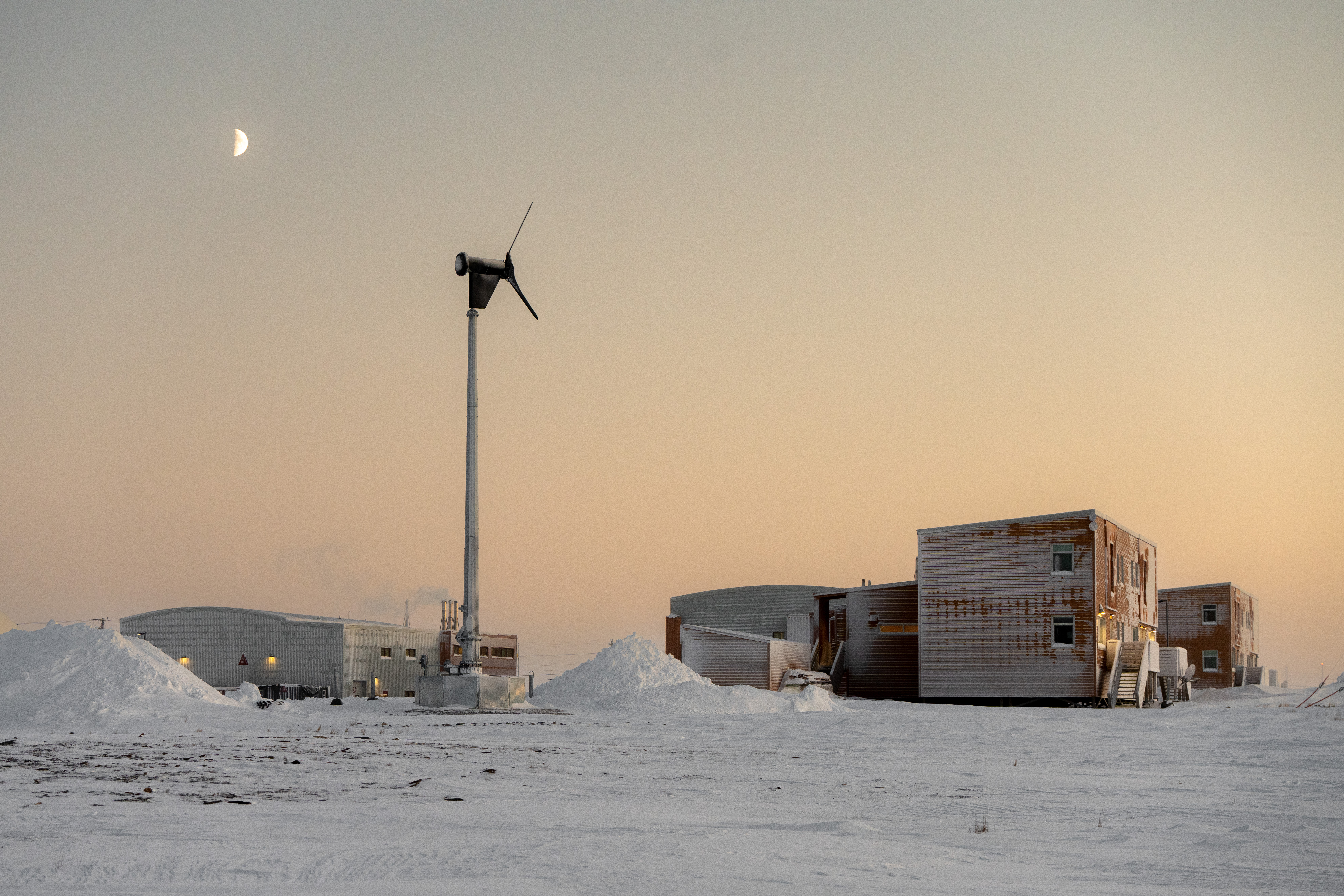 Winter view of CHARS campus. A wind turbine sits between the larger Field Maintenance Building and two low buildings.