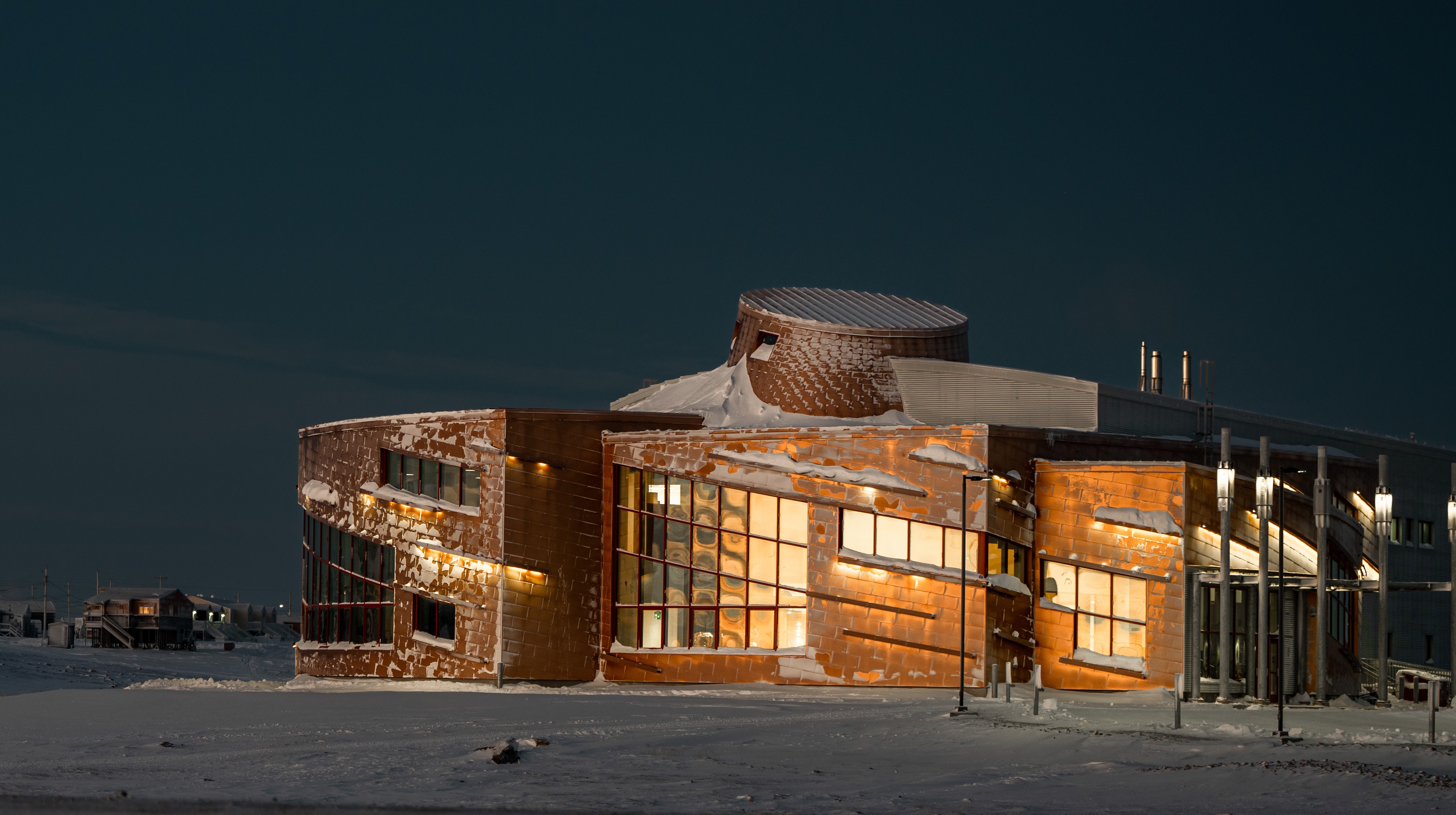 Outside view of the entrance to CHARS’ Main Research Building, taken in twilight with dusting of snow on the ground and on the building.
