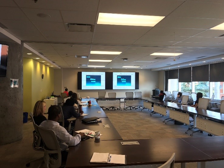 People in a boardroom looking at a presentation on a projector screen