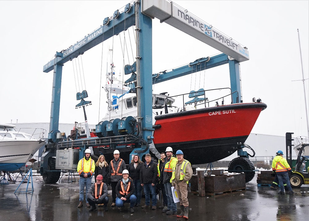 Canadian Coast Guard Ship Cape Sutil on a lift with a group of workers standing in front