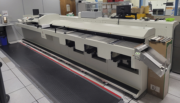A long beige industrial scanner alongside a black rubber carpet runner