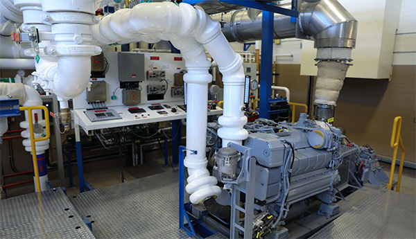 The exhaust pipes emerging from a ship engine’s mechanical components