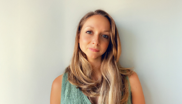 Portrait of a woman with long hair wearing a light green sweater.
