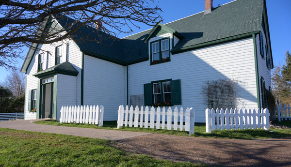A white house with green gables on a sunny day.