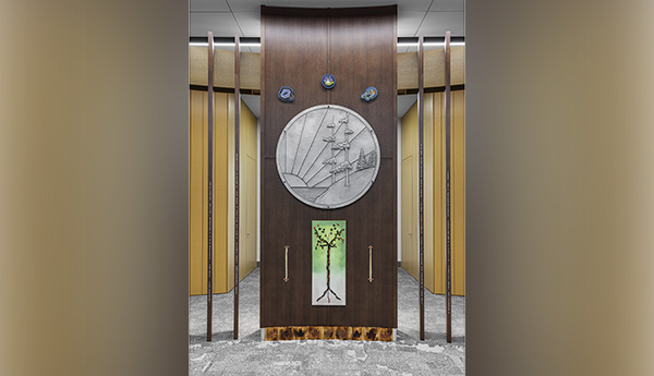 Pièce de bois verticale sur laquelle se trouvent une œuvre d'art circulaire, au-dessus 3 œuvres en forme de bulle et en dessous une œuvre rectangulaire verte et blanche sur laquelle figure un arbre.