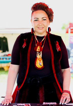 Vanessa Brousseau standing in front of a table wearing Indigenous jewelry.
