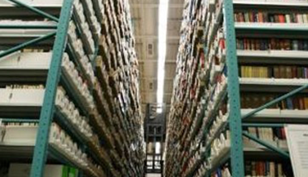 2 large floor-to-ceiling metal shelves with boxes of files