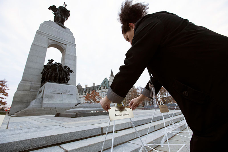 An employee setting up wreath stands in front of the National War Memorial in Ottawa, Ontario