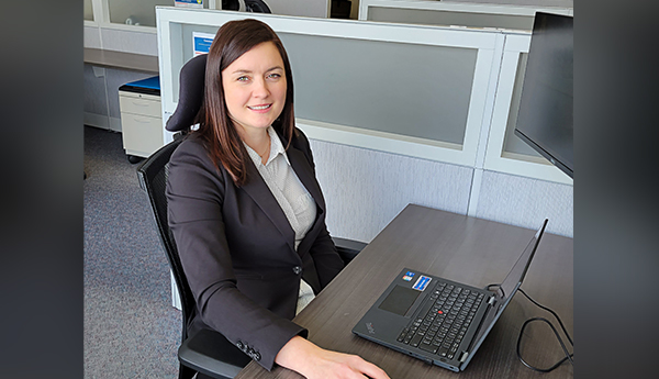 Mélanie Rivard est assise à un poste de travail.