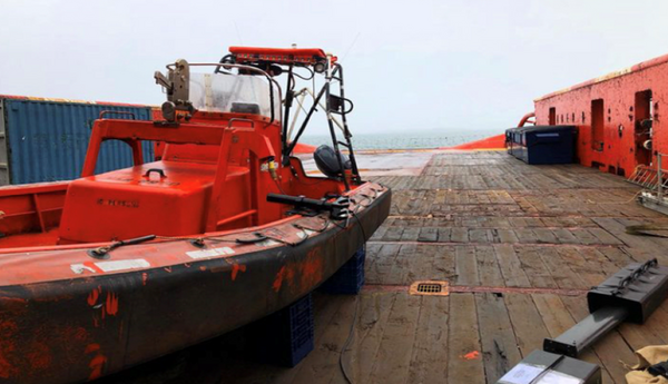 A small orange boat on a wharf