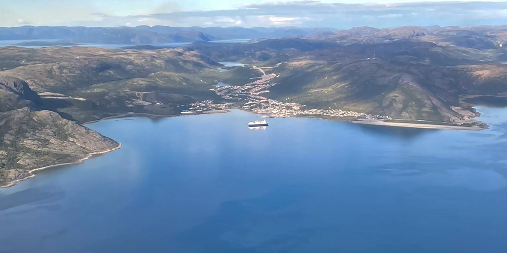 An aerial photo of a green land mass surrounded by blue water