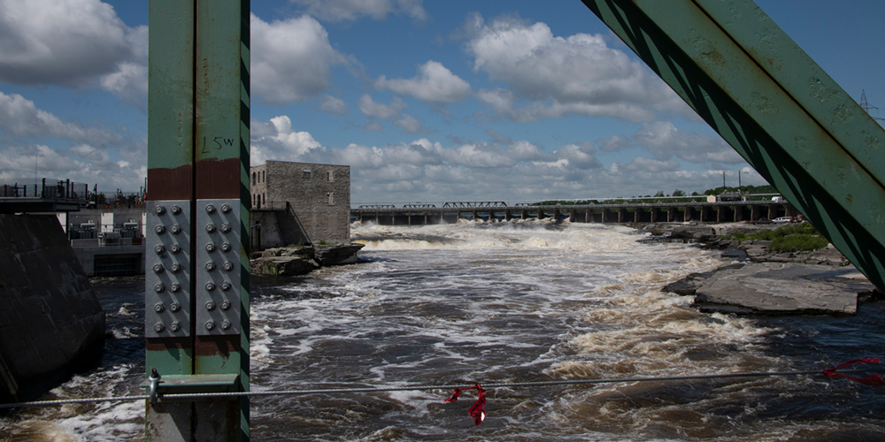 Gros plan de la structure d'un pont, à l'arrière de laquelle coule une rivière.
