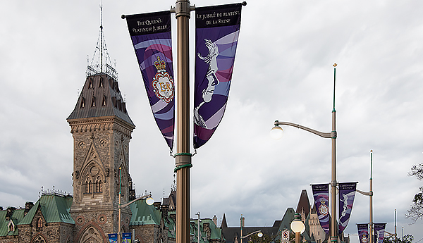 Jubilee flags on a flag pole with Parliament buildings in the background.