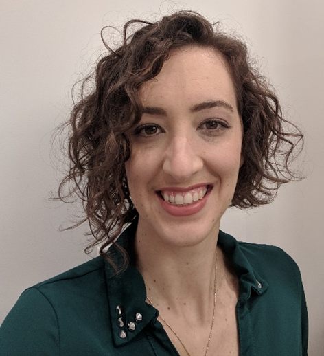 Smiling woman with wavy hair wearing a black blouse.