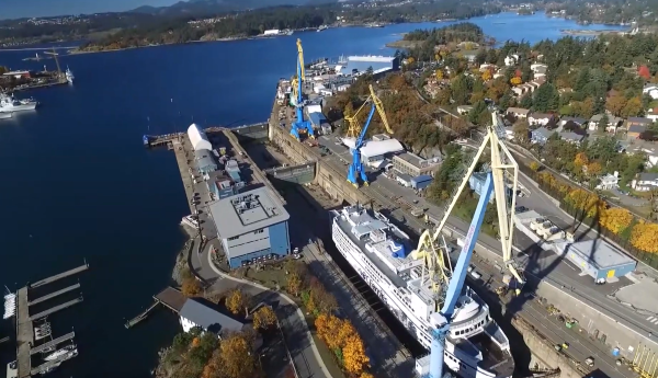 Vue aérienne de la cale sèche d’Esquimalt et d’un grand navire accosté sous une grue.