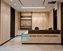 Enlarged image of the reception desk with guided tours signage, located beside a glass partition within the renovated West Memorial Building atrium.