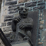 A stone carving of an animal on the wall of a stone building