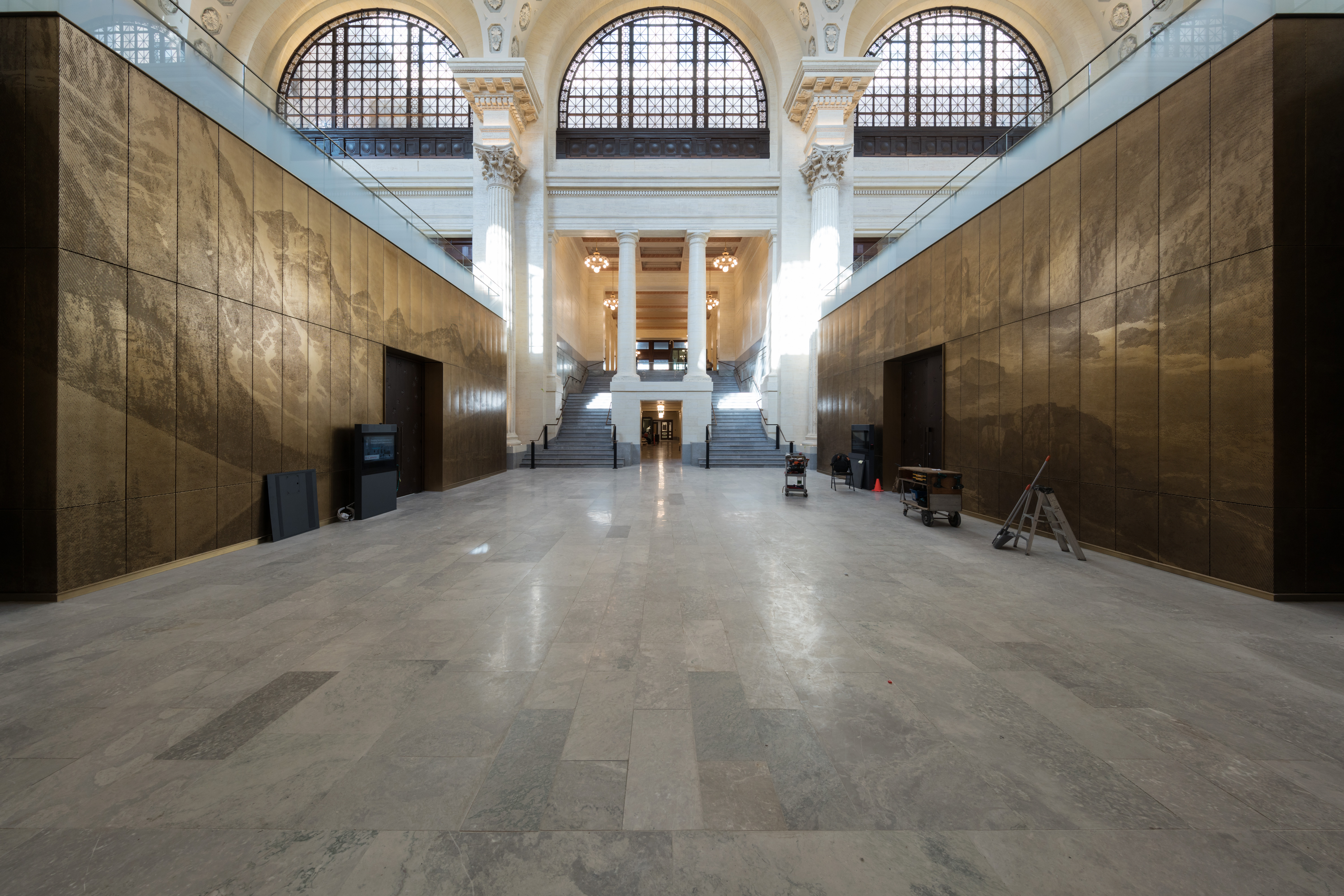 2018 - The finished room. The staircase is restored. There are two committee rooms on each side of the space covered with perforated bronze panels representing east and west sceneries. The floor is original marble.