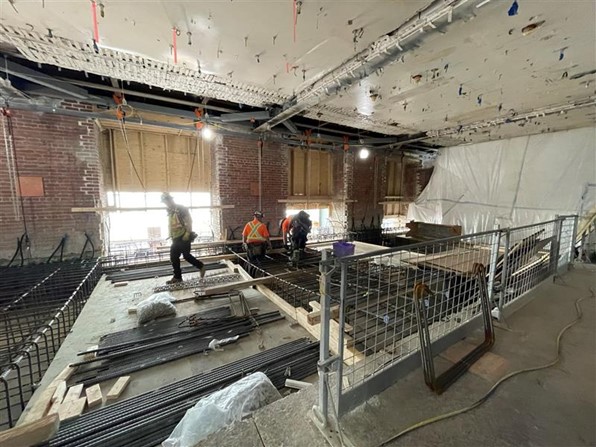 Demolished section of the first floor slab with steel rebar being installed before pouring concrete