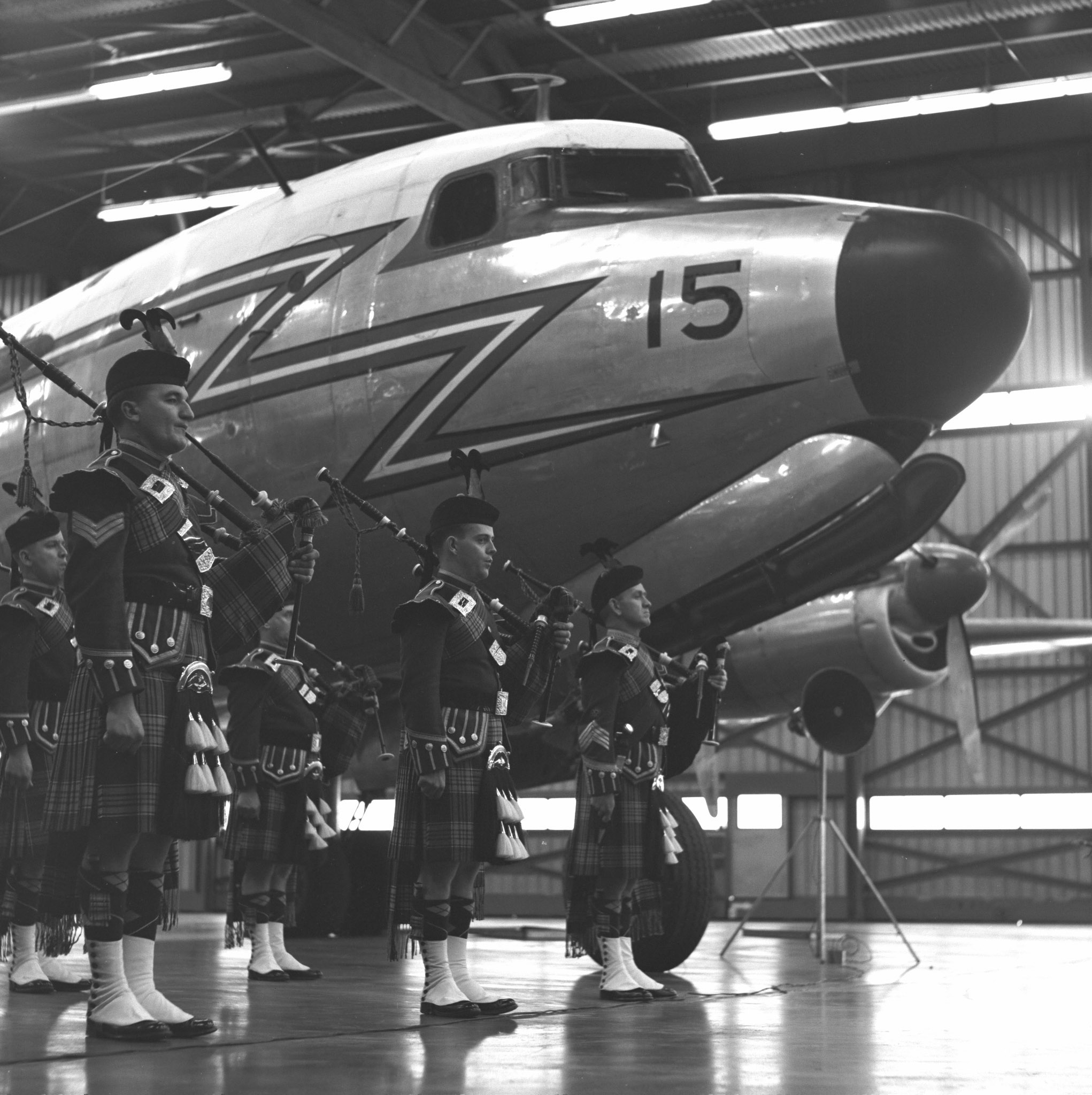 Des militaires du Corps de cornemuses de l’ARC se tiennent devant le dernier North Star de l’ARC pendant la cérémonie de retrait du service de l’avion. PHOTO : Archives du MDN, Z-10578-2