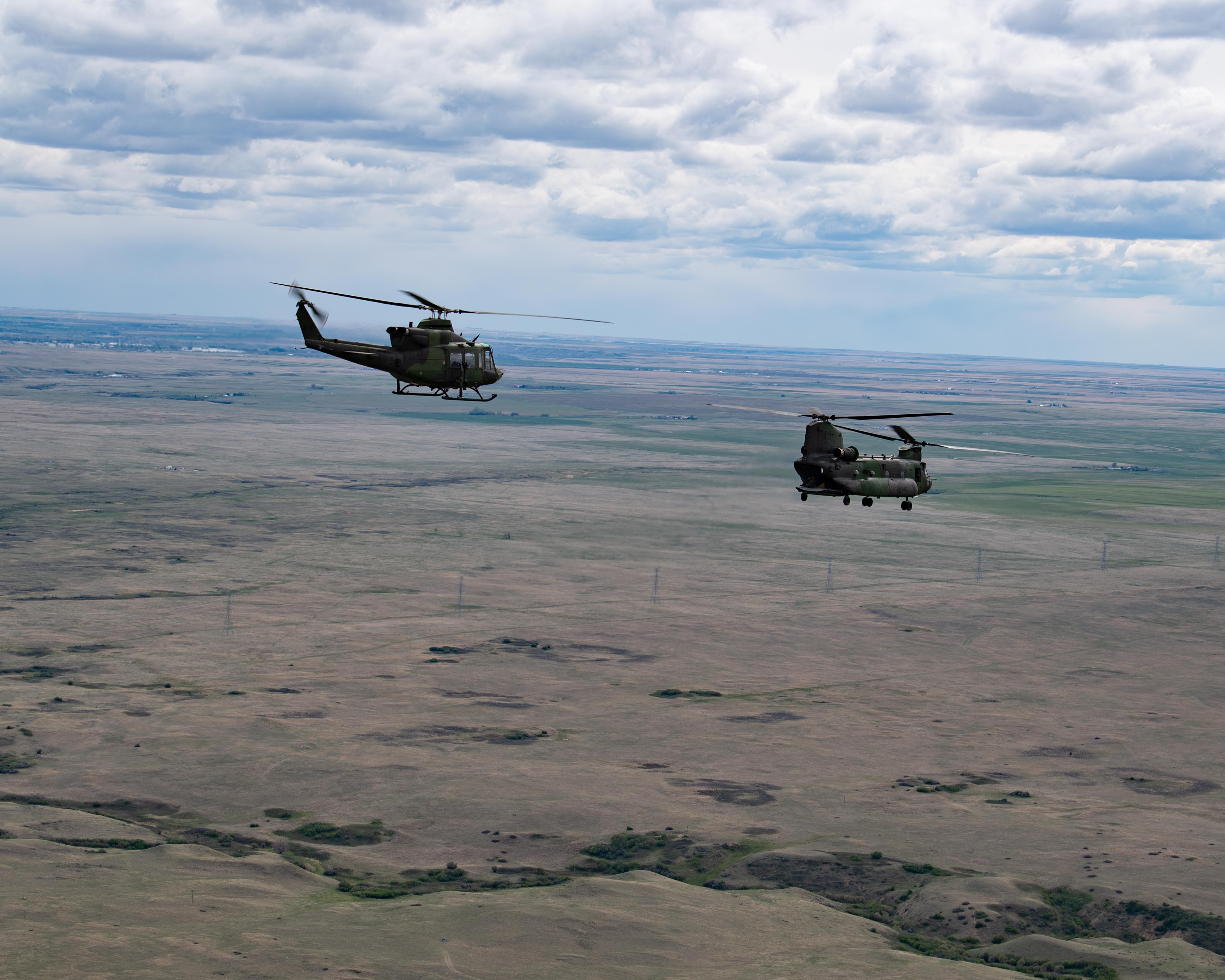 Un CH-146 Griffon et un CH-147 Chinook survolent la BFC Suffield lors d’un scénario du Cours d’aviation tactique de base, le 19 mai 2021. PHOTO: Cpl Laura Landry