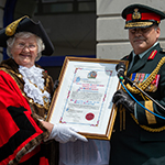 La conseillère municipale Ann Berry, maire de Folkestone, présente au brigadier-général Lowell Thomas, commandant de l’État-major de liaison des Forces canadiennes à Londres, le parchemin officialisant le droit de cité, le 4 juillet 2018. PHOTO: MCpl Boucher
