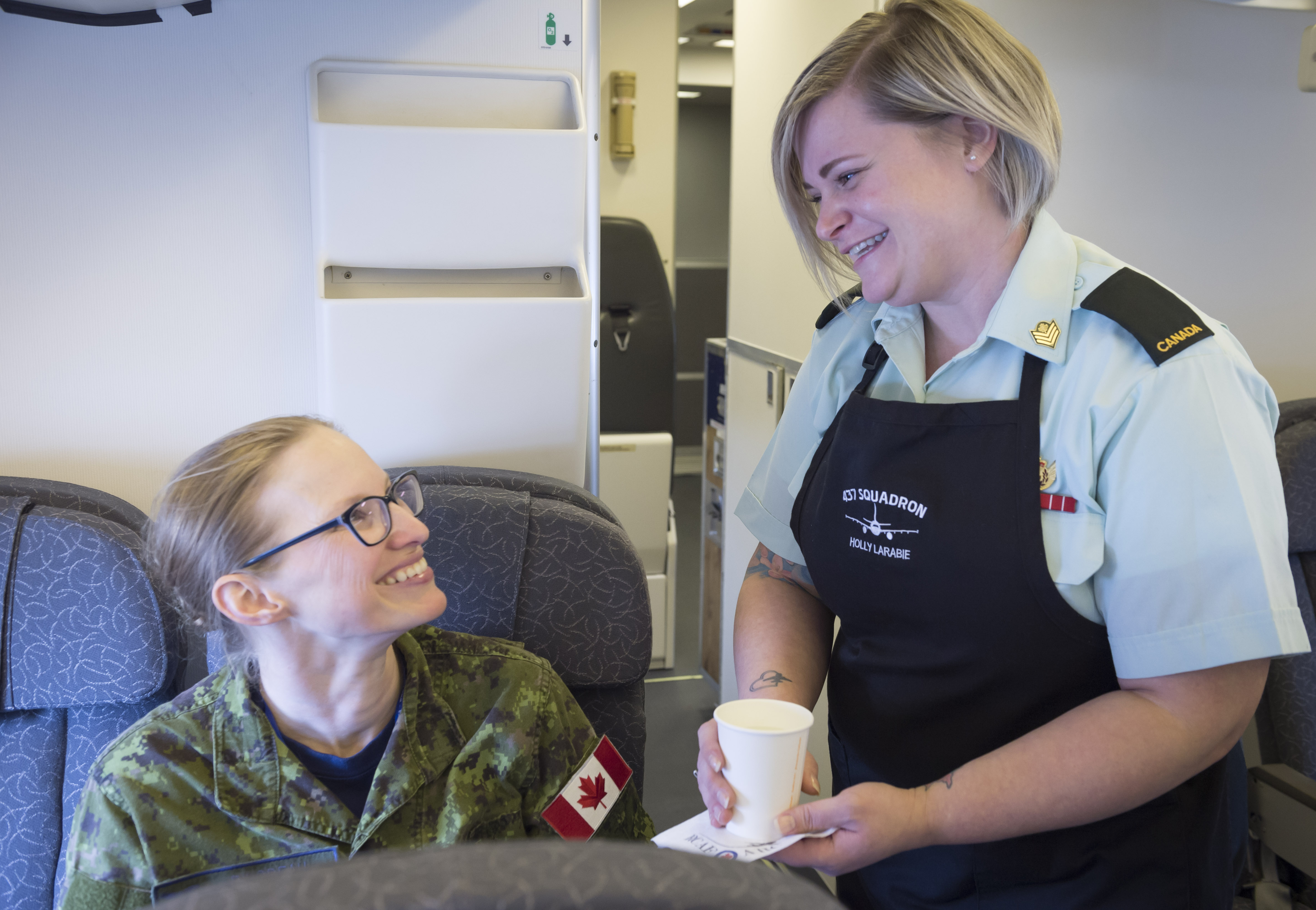 La sergent Holly Larabie (à droite) dit  que son rôle à bord dépassait largement le simple fait de veiller au confort des passagers.
Photo : Section d’imagerie, 8e Escadre.