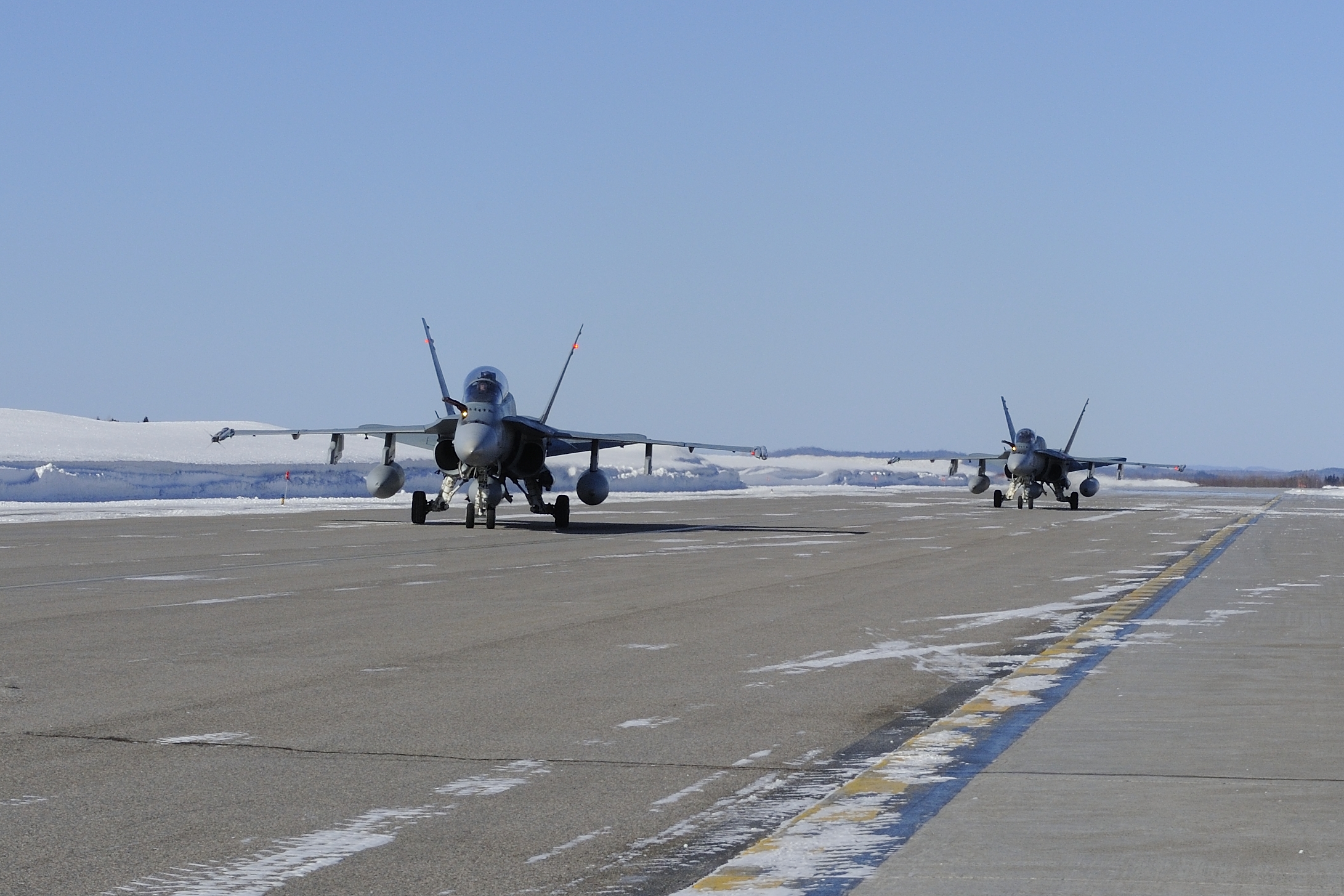 Two CF-18 Hornets land at Ottawa International Airport after escorting a CC-177 Globemaster carrying Canadian Armed Forces members returning from the last mission in Afghanistan on March 18, 2014. PHOTO: Corporal Jean-Roch Chabot
