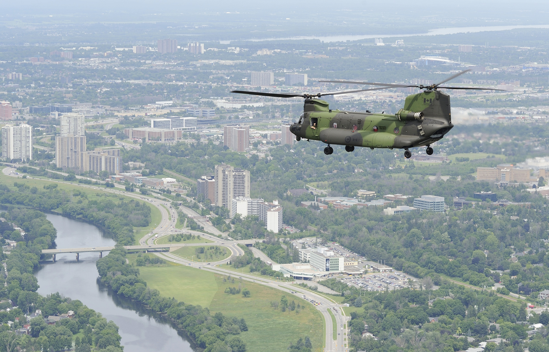 A new Royal Canadian Air Force CH-147F Chinook medium- to heavy-lift helicopter overflies the Rideau River in Ottawa, Ontario, en route to its new home with 450 Tactical Helicopter Squadron at Canadian Forces Base Petawawa, Ontario, on June 27, 2013. PHOTO: Corporal Darcy Lefebvre