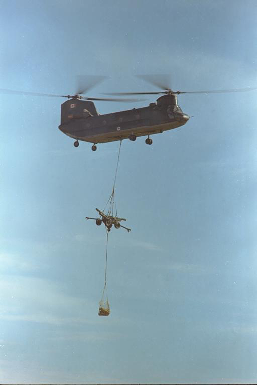 A 450 Transport Helicopter Squadron CH-147 Chinook with under-slung L-5 guns and ammunition approaches a drop zone. PHOTO: ISC77-1069, DND Archives